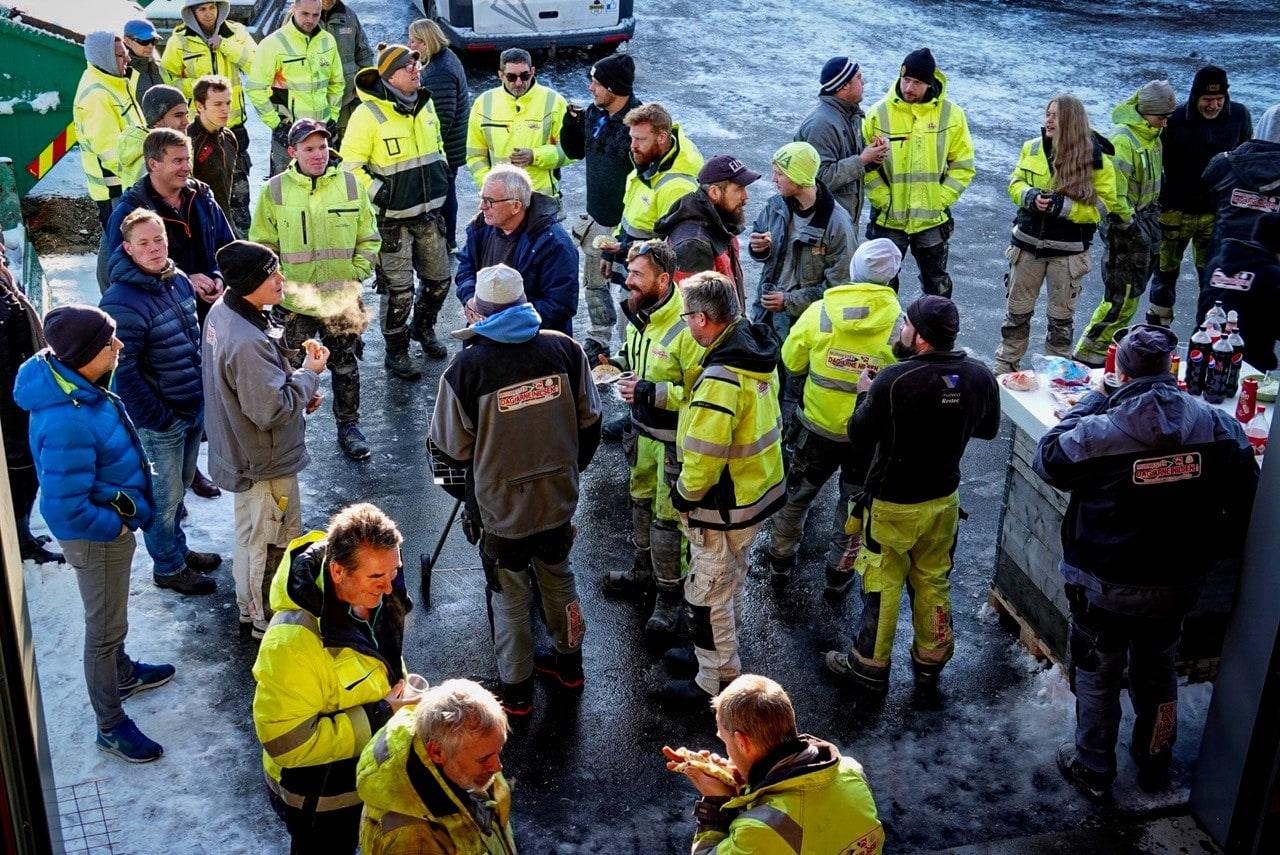 Store deler av gjengen samlet utendørs, de fleste i gule arbeidsklær